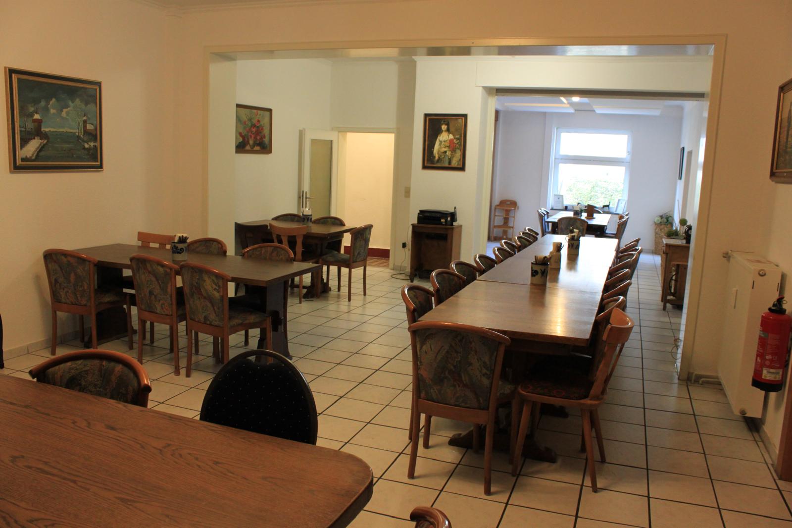 Veranstaltungsraum mit langer Tafel und mehreren Tischen